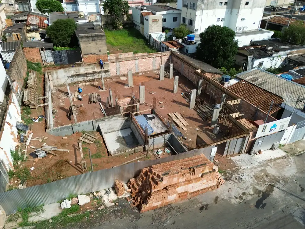 Vista aérea da obra do Edifício Elegance em outubro de 2026, com pilares do subsolo e muros de contenção